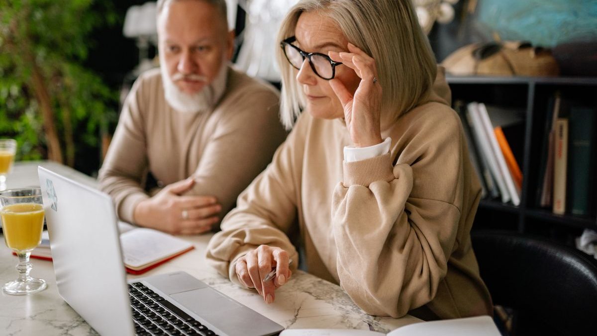 An older couple reviewing plans and finances on a laptop at home