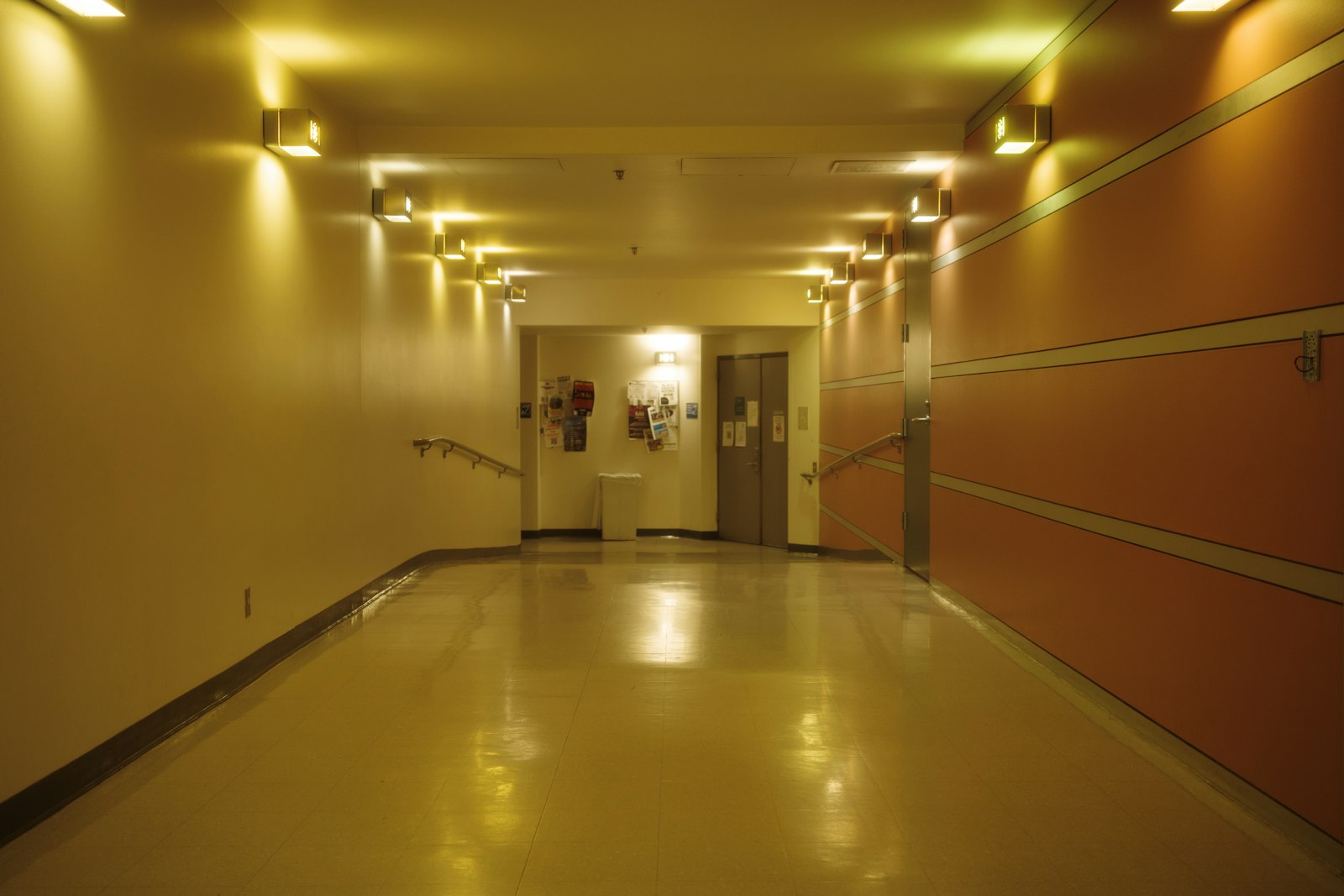Empty hospital hallway with doors at the far end, no people